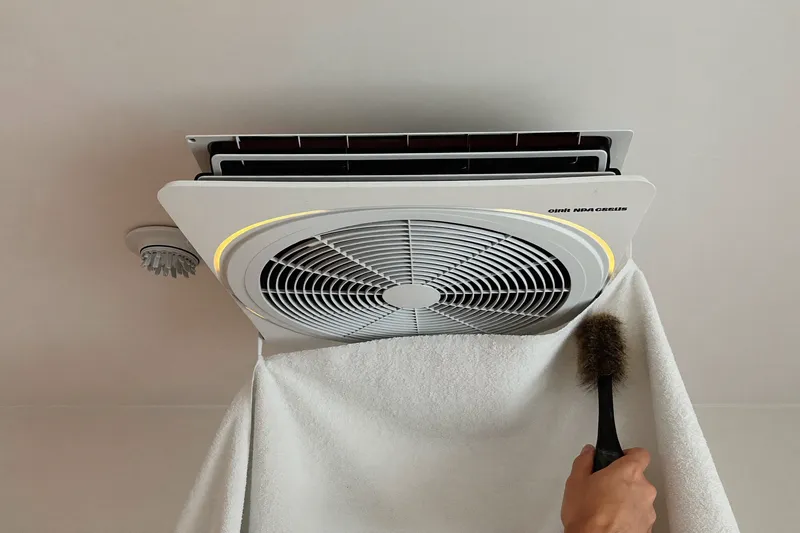 Square ceiling air diffusers taken down and washed with a soft brush on a towel in a bathtub